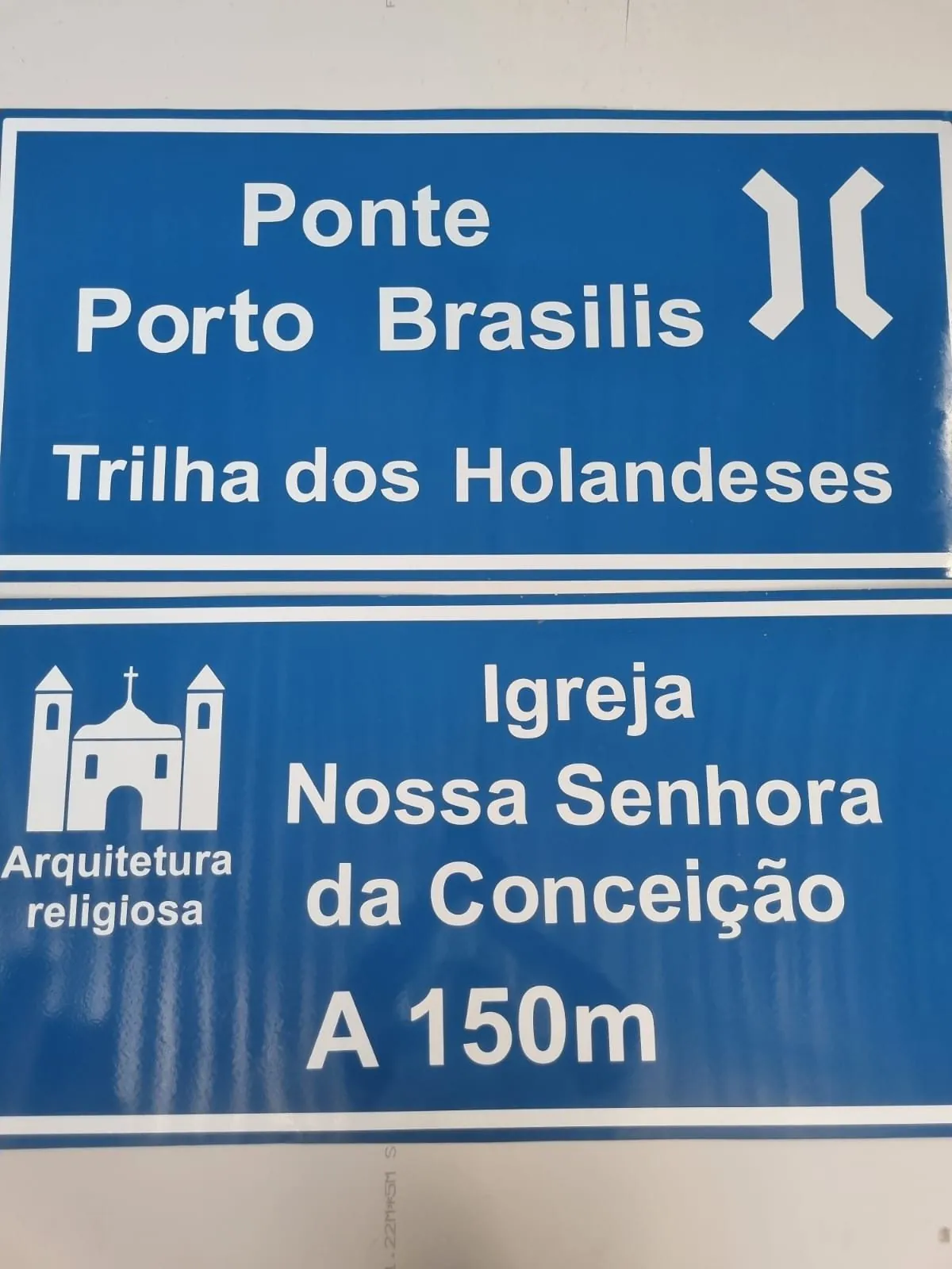 Placas de indicação turística azuis fabricadas pela Belplac: Ponte Porto Brasilis, Trilha dos Holandeses e Igreja Nossa Senhora da Conceição, em Itamaracá, Pernambuco