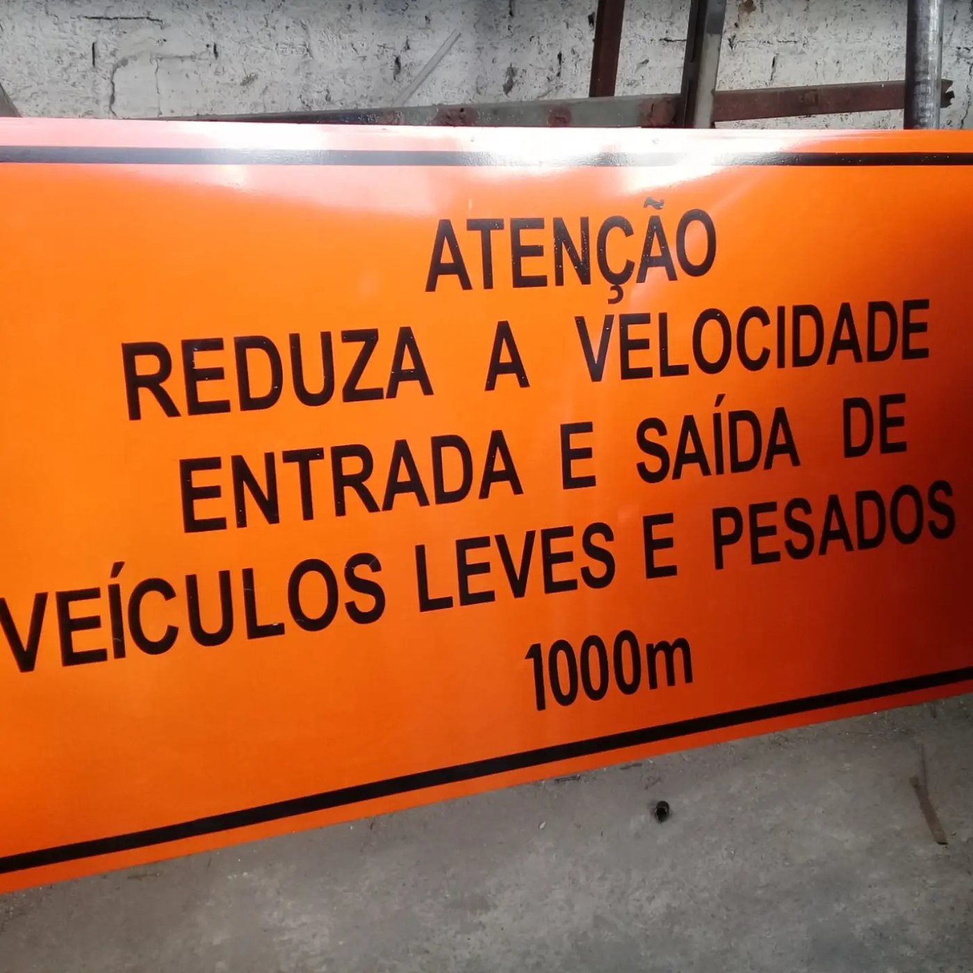 Placa de advertência laranja de entrada e saída de veículos leves e pesados